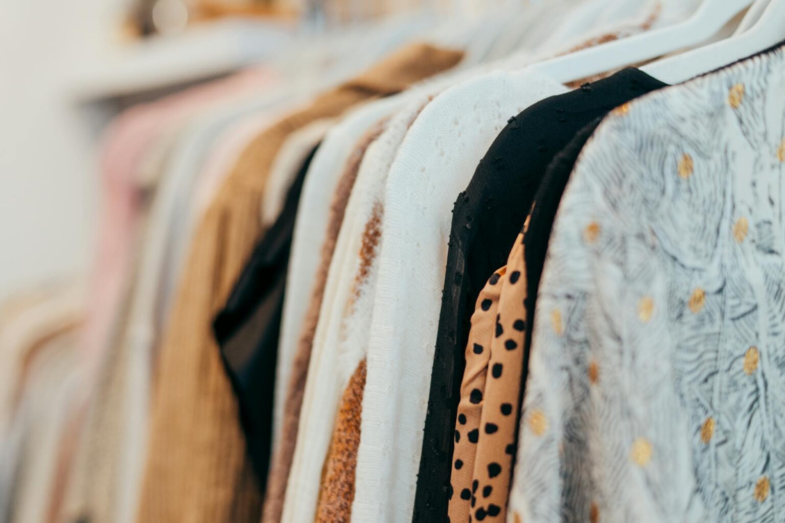 How Vintage Band Tees Became the Ultimate Designer Statement Piece Vintage clothing displayed on hangers showing various aged band t-shirts and rock merchandise