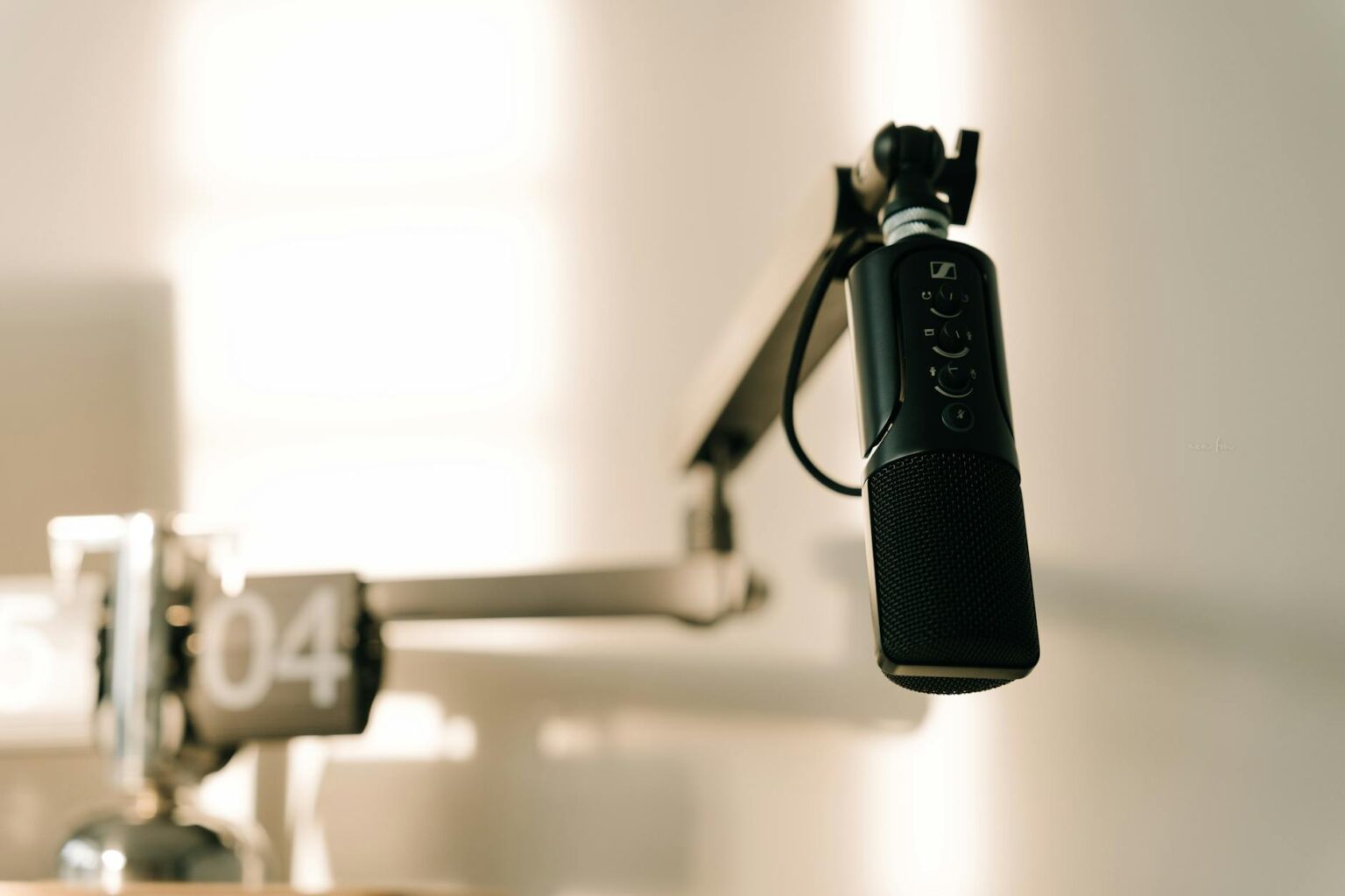 How Podcasters Are Launching Traditional Radio Show Comebacks Professional radio microphone in broadcasting studio with equipment in background