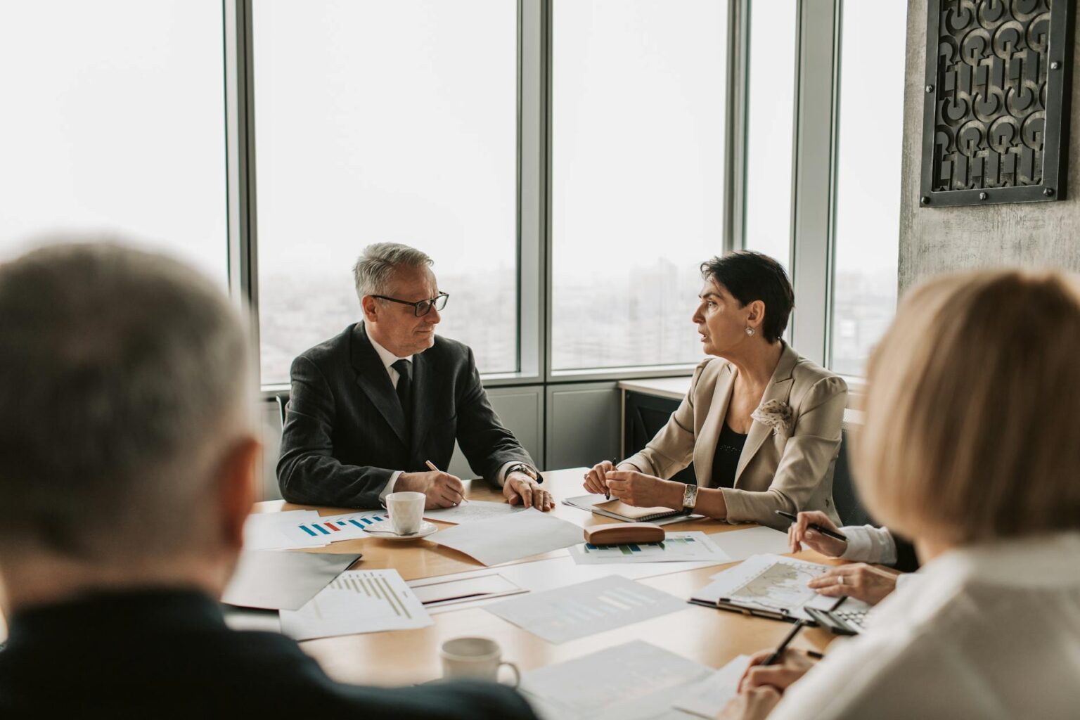 Professional business meeting in modern office setting with executives discussing strategy