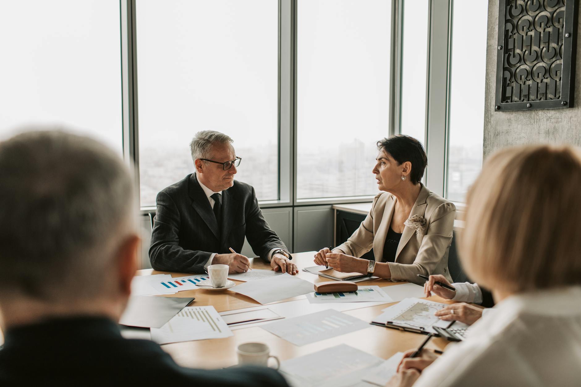 Professional business meeting in modern office setting with executives discussing strategy