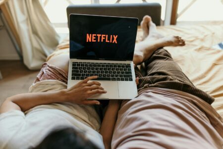 Person watching streaming content on laptop screen in dark room