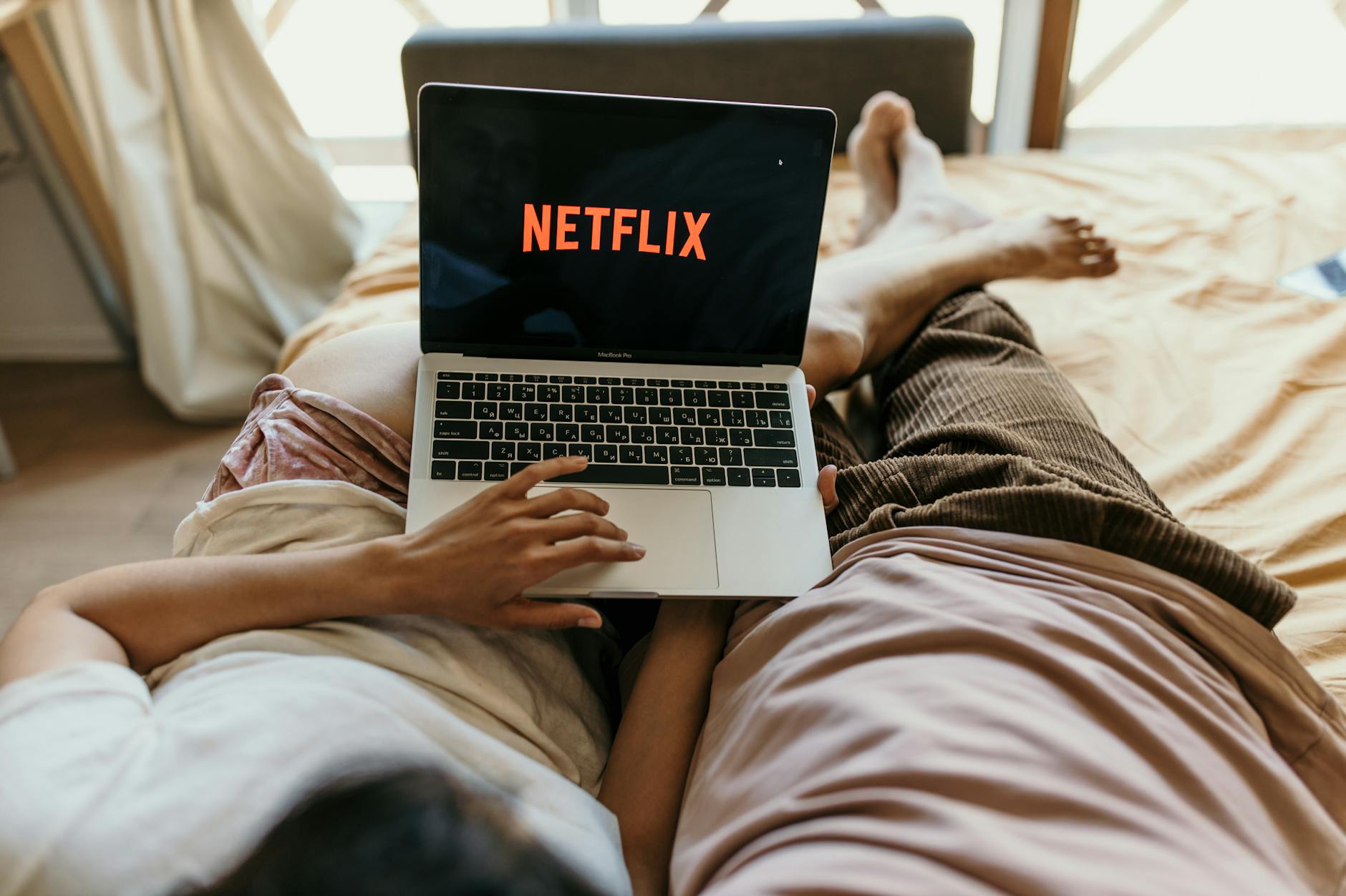 Person watching streaming content on laptop screen in dark room