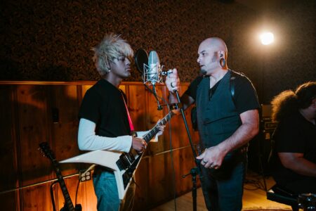 How Ryan Gosling’s Band Is Influencing Other Actors’ Music Careers Musicians recording in a professional studio with instruments and equipment