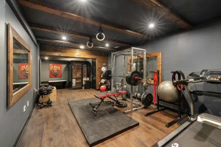 Why Wealthy Families Are Hiring Full-Time Wellness Coordinators Modern home gym with professional exercise equipment and natural lighting