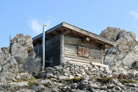 Why High-Earners Are Moving to Remote Mountain Towns Permanently Modern mountain cabin home with large windows overlooking scenic valley landscape