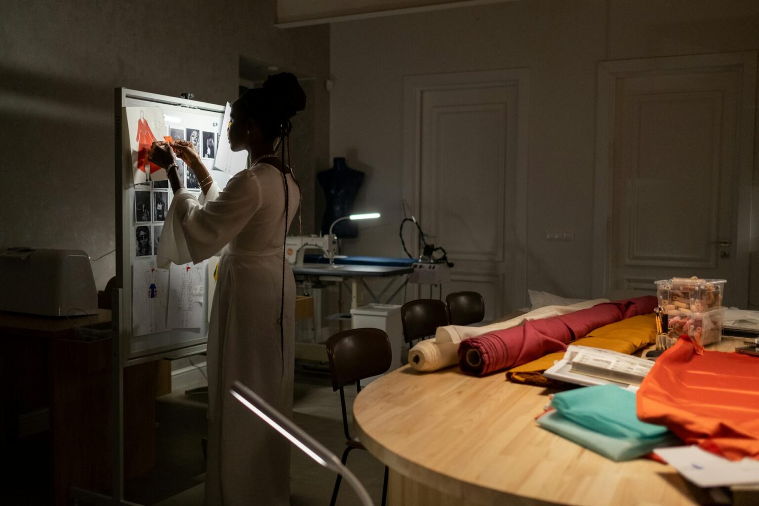 Fashion design studio workspace with sketches, fabrics, and design tools
