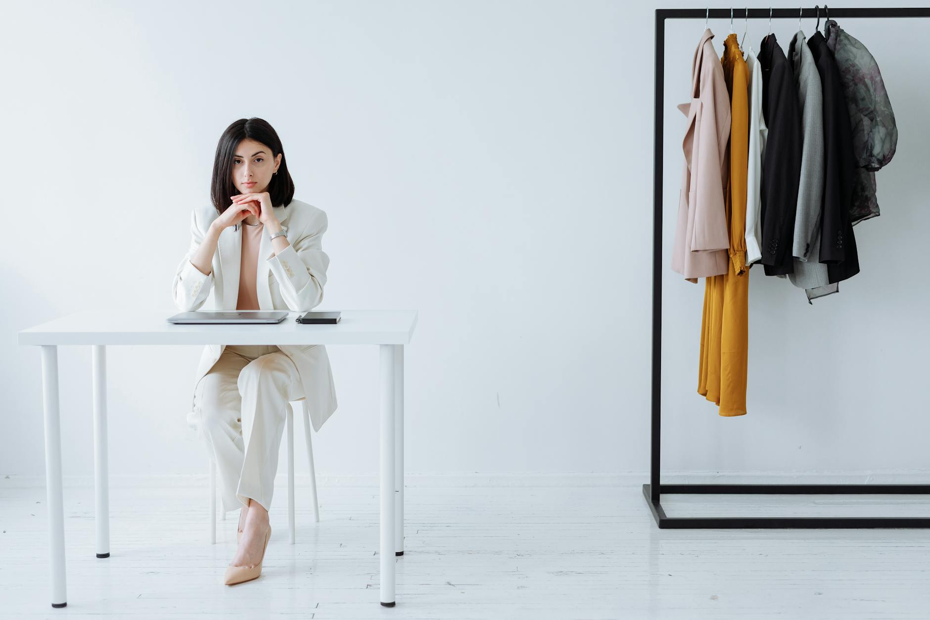Clean minimalist clothing hanging on rack showing neutral tones and simple silhouettes