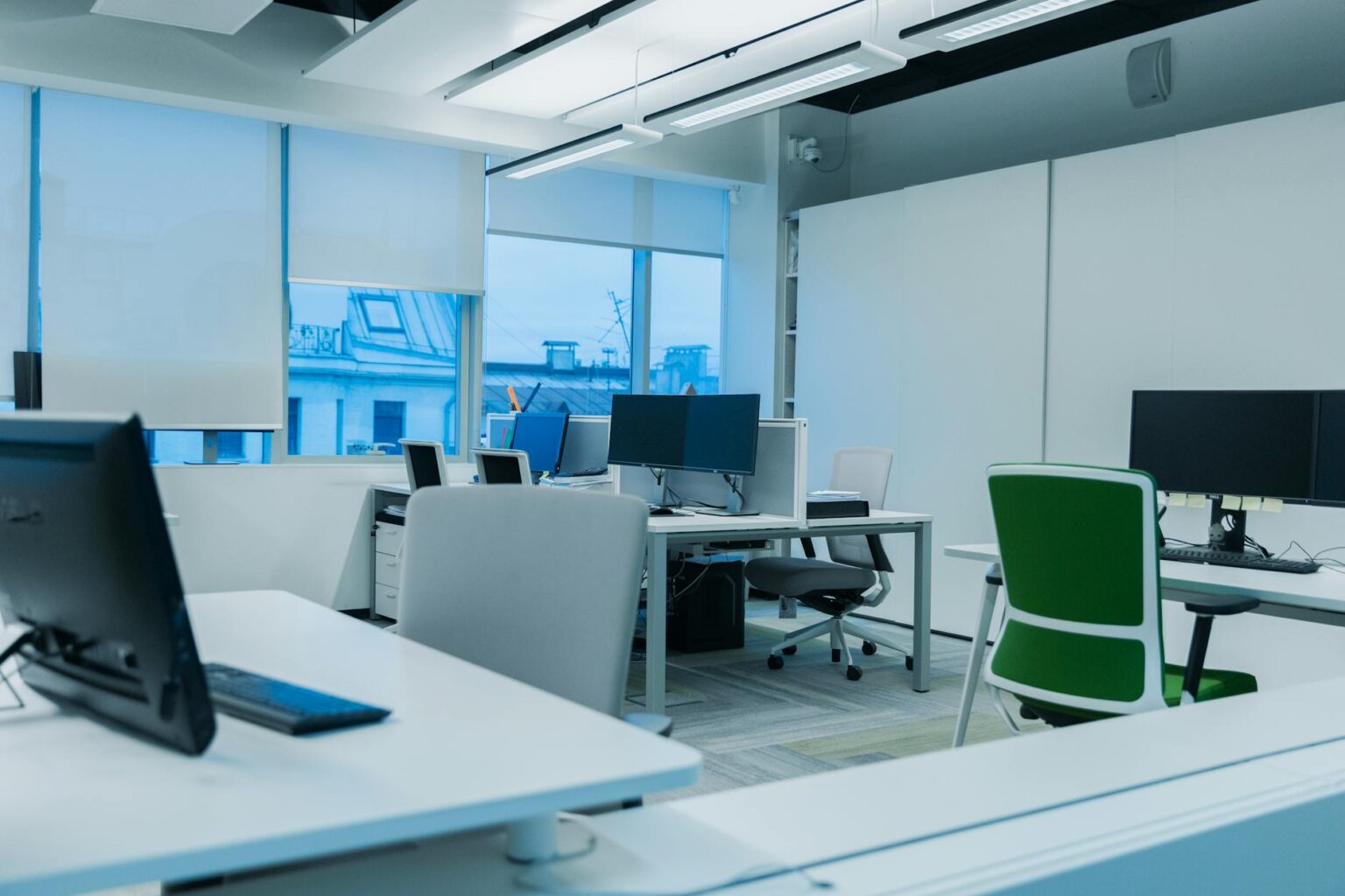 Modern minimalist office space with clean desks and professional lighting for focused work
