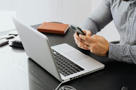 Why Executives Are Hiring Professional Digital Detox Coaches Business desk with smartphone and laptop showing digital workspace setup