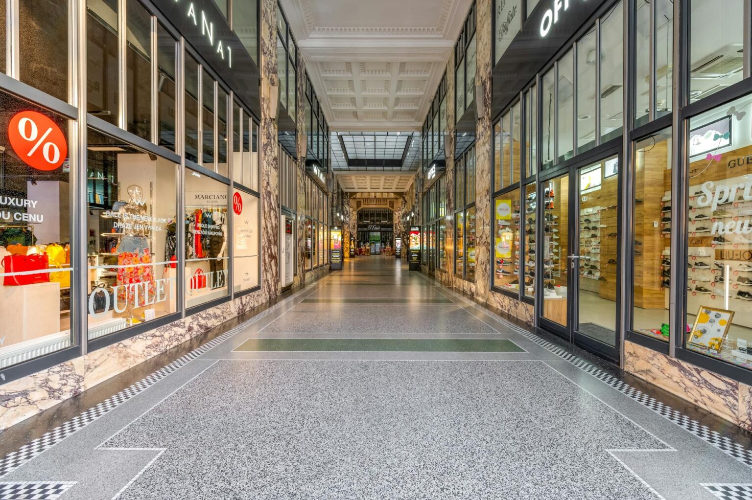 The Unexpected Mall Brands Celebrities Are Wearing to Casual Events Modern shopping mall interior with storefronts and shoppers walking through corridors