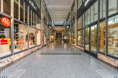 The Unexpected Mall Brands Celebrities Are Wearing to Casual Events Modern shopping mall interior with storefronts and shoppers walking through corridors