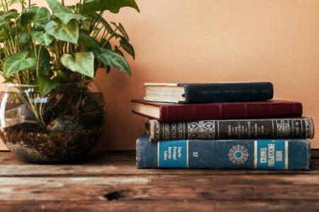 Inside Reese Witherspoon’s Book Club Empire and Publishing Partnerships Stack of books on wooden table representing book club selections