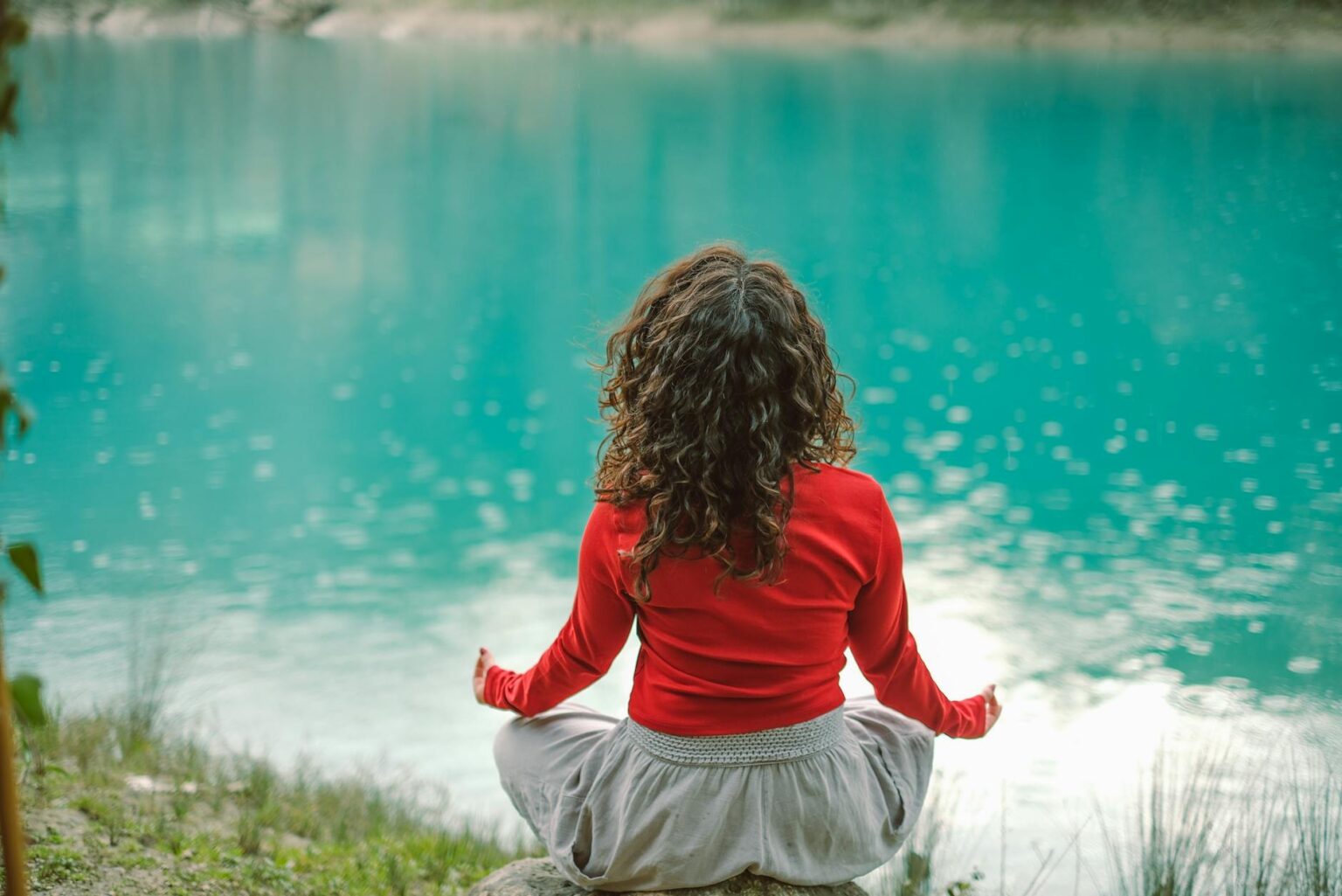 Person meditating peacefully in natural outdoor setting