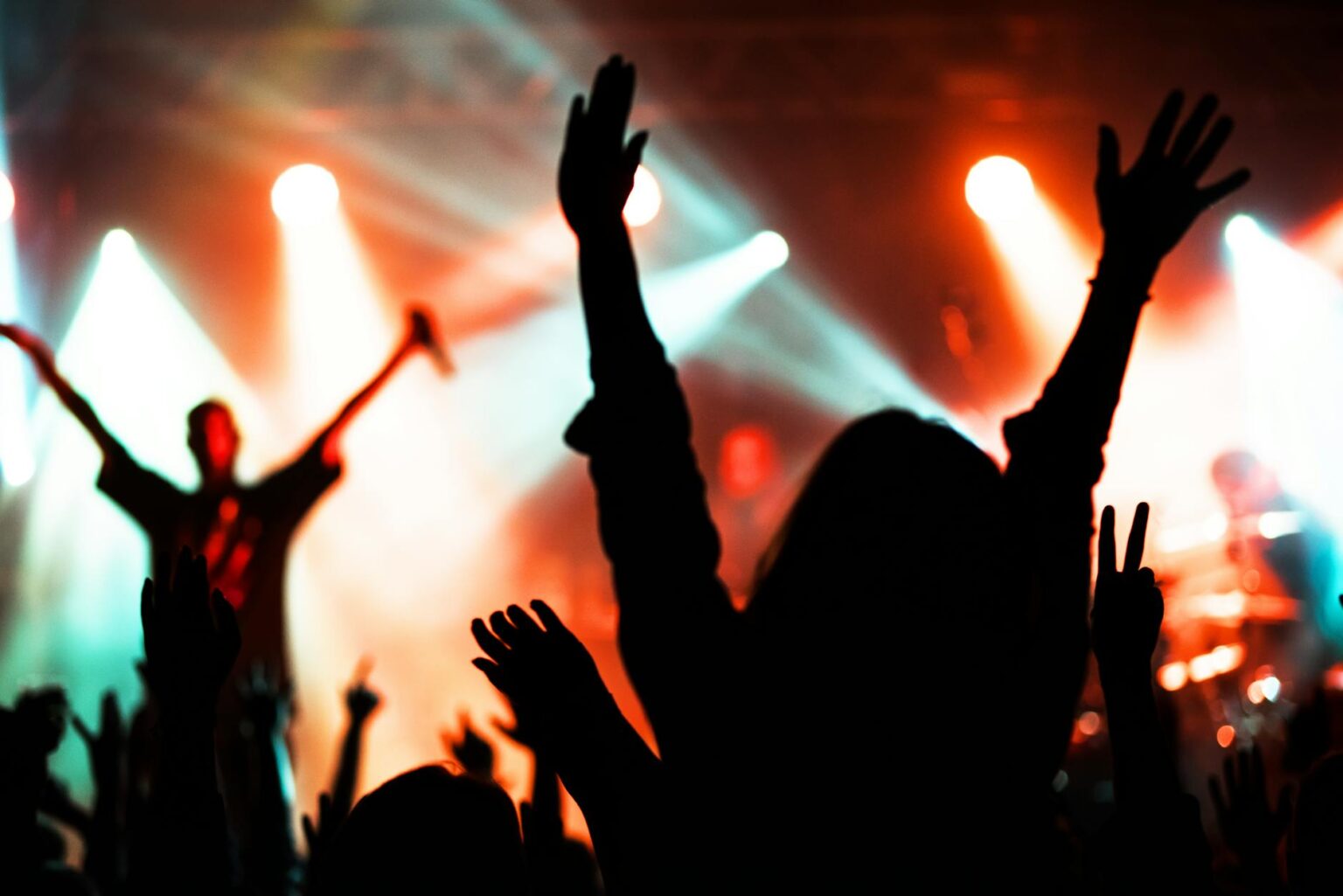 How Virtual Reality Concerts Are Creating New Fan Experiences Silhouettes of concert audience with colorful stage lights creating an immersive atmosphere