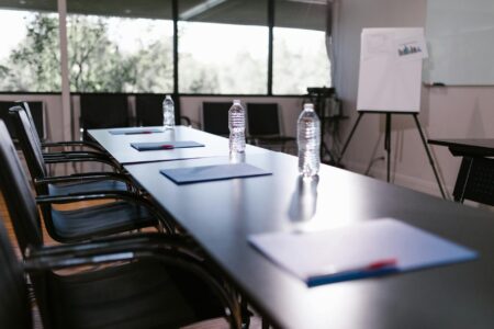 How Scarlett Johansson’s Wellness Brand Is Expanding Into Corporate Retreats Business professionals in a modern conference room during a corporate meeting