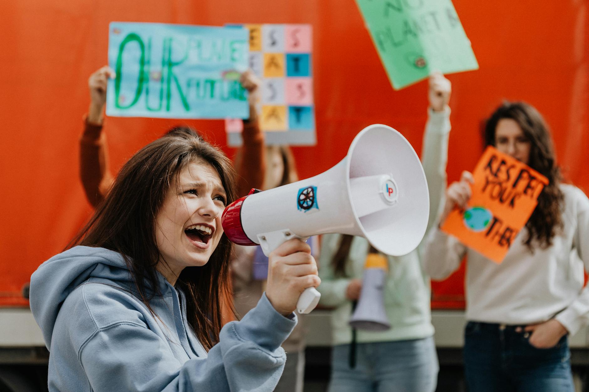 People gathered at an outdoor environmental awareness event with signs and banners