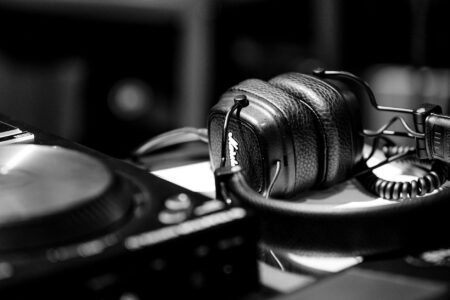 Person wearing headphones listening to music on smartphone with streaming app interface visible