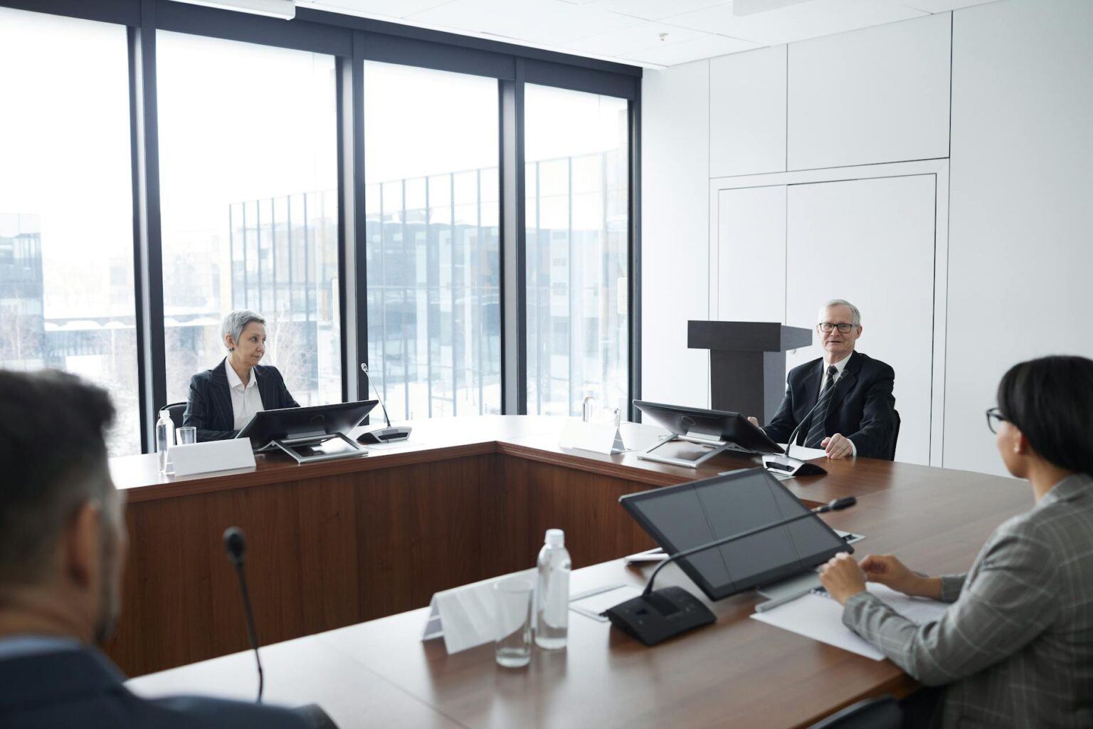 Professional business meeting with documents and handshakes representing corporate acquisitions