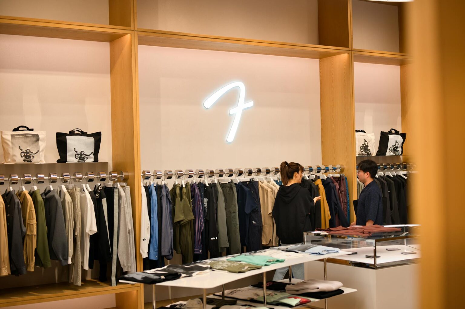 The Unexpected Luxury Brands Collaborating With Fast Fashion Giants Modern fashion retail store interior with clothing displays and contemporary lighting