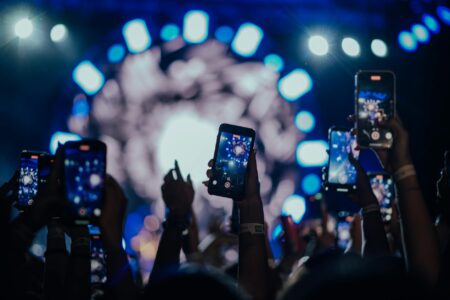 Person holding smartphone recording a live musical performance