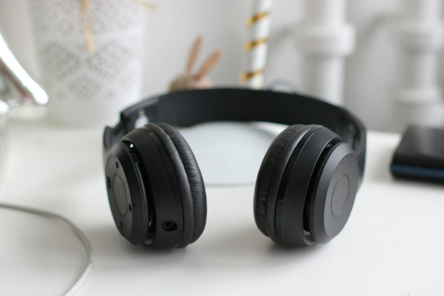 Audio headphones on desk with computer screen showing audio editing software