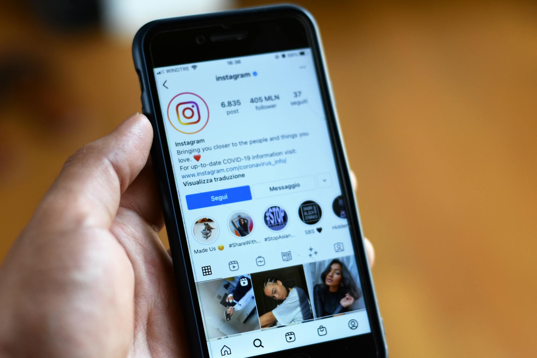 Person holding smartphone showing social media interface with engagement metrics