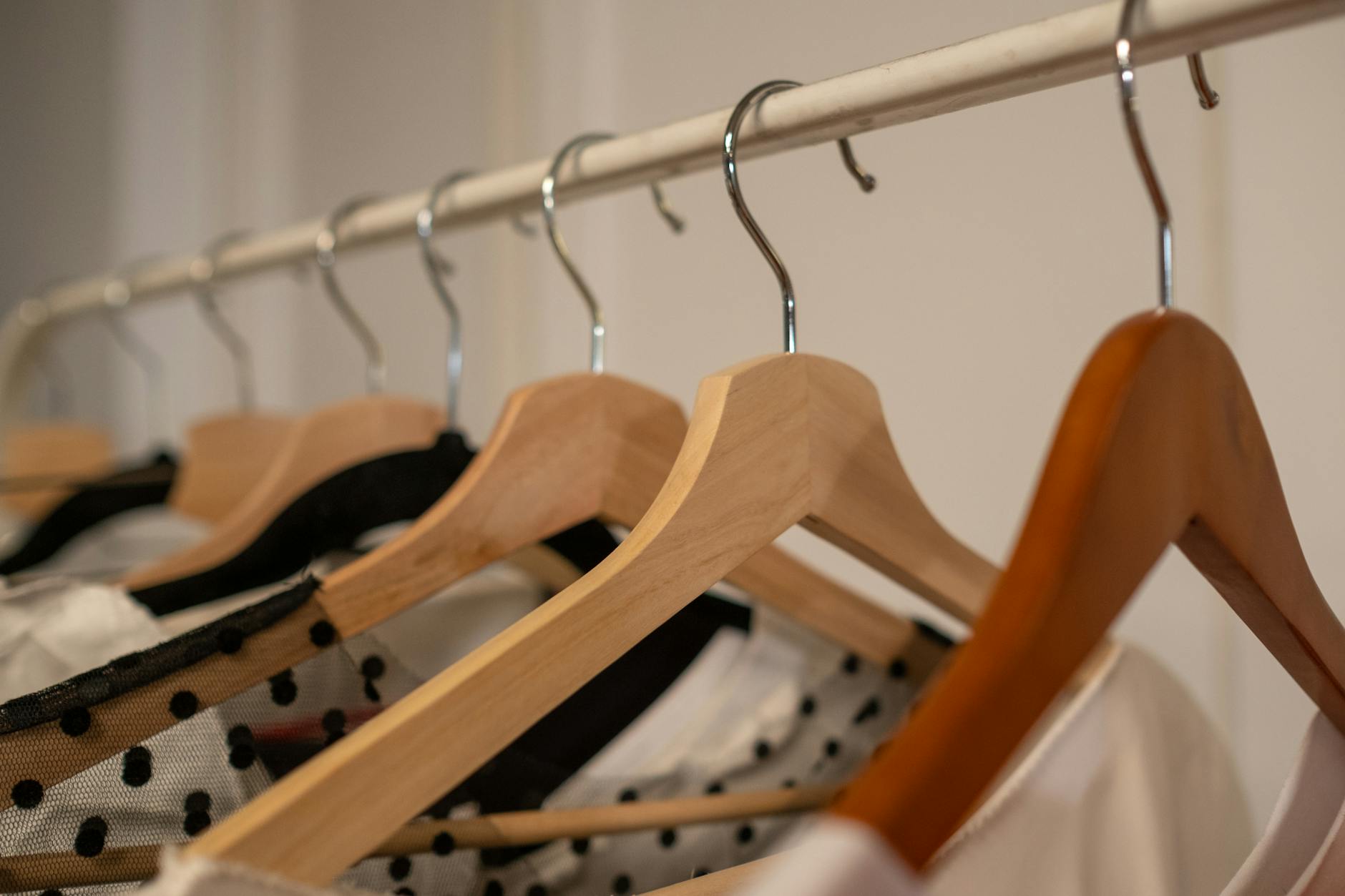 Organized closet with neutral colored clothing and clean minimal aesthetic