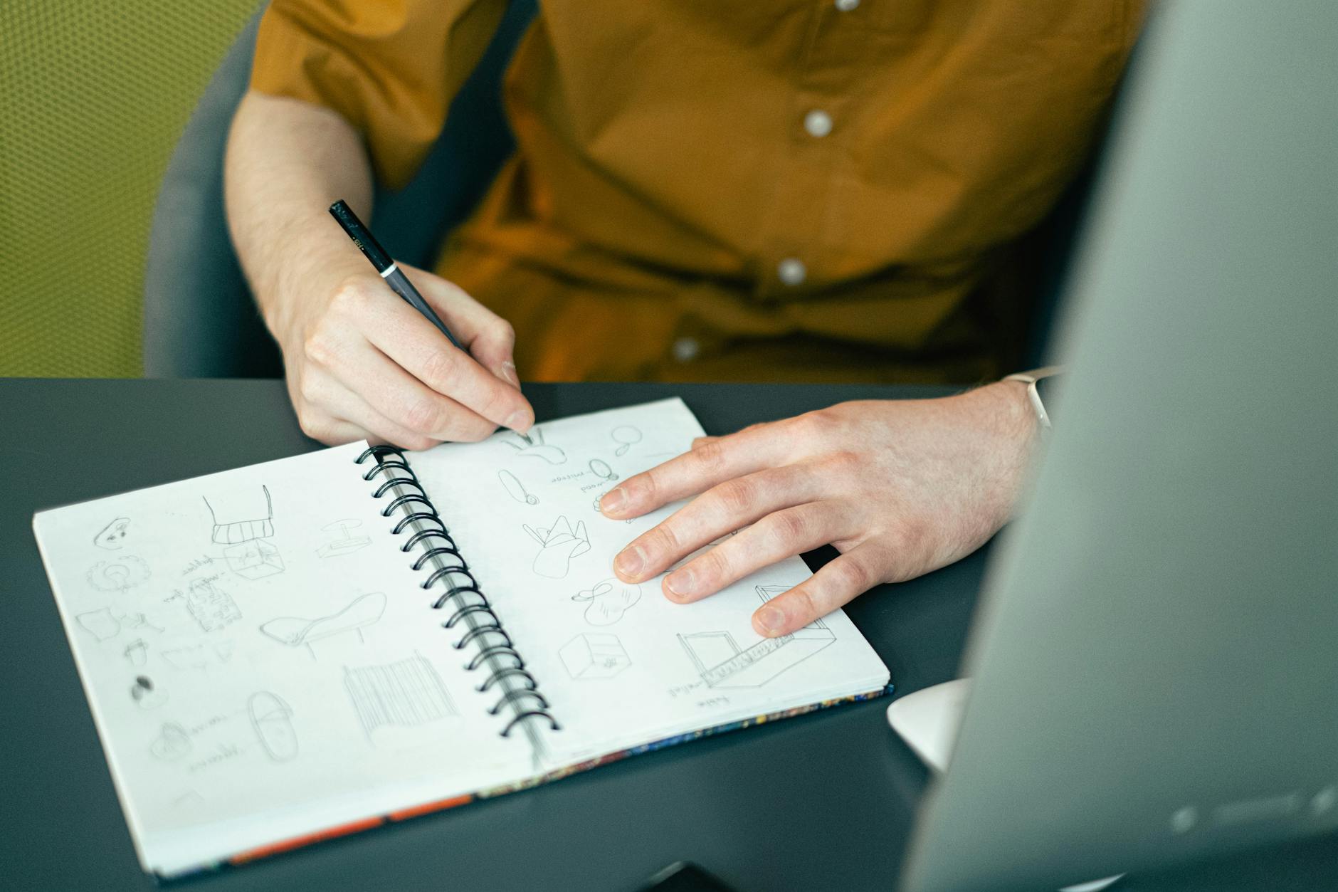 Fashion designer working on clothing sketches at a design table