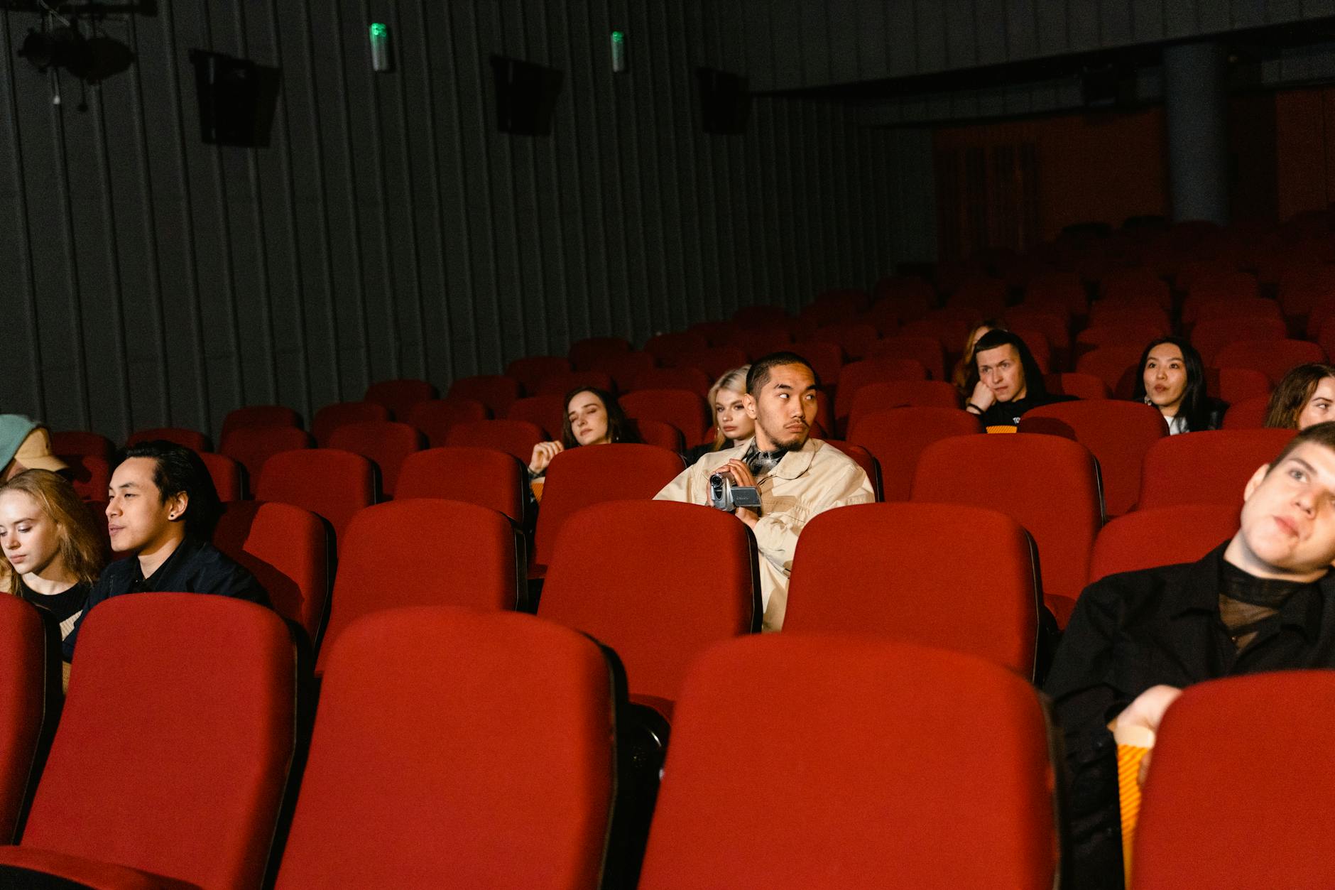 Large audience of people watching entertainment content on screens, engaged and focused