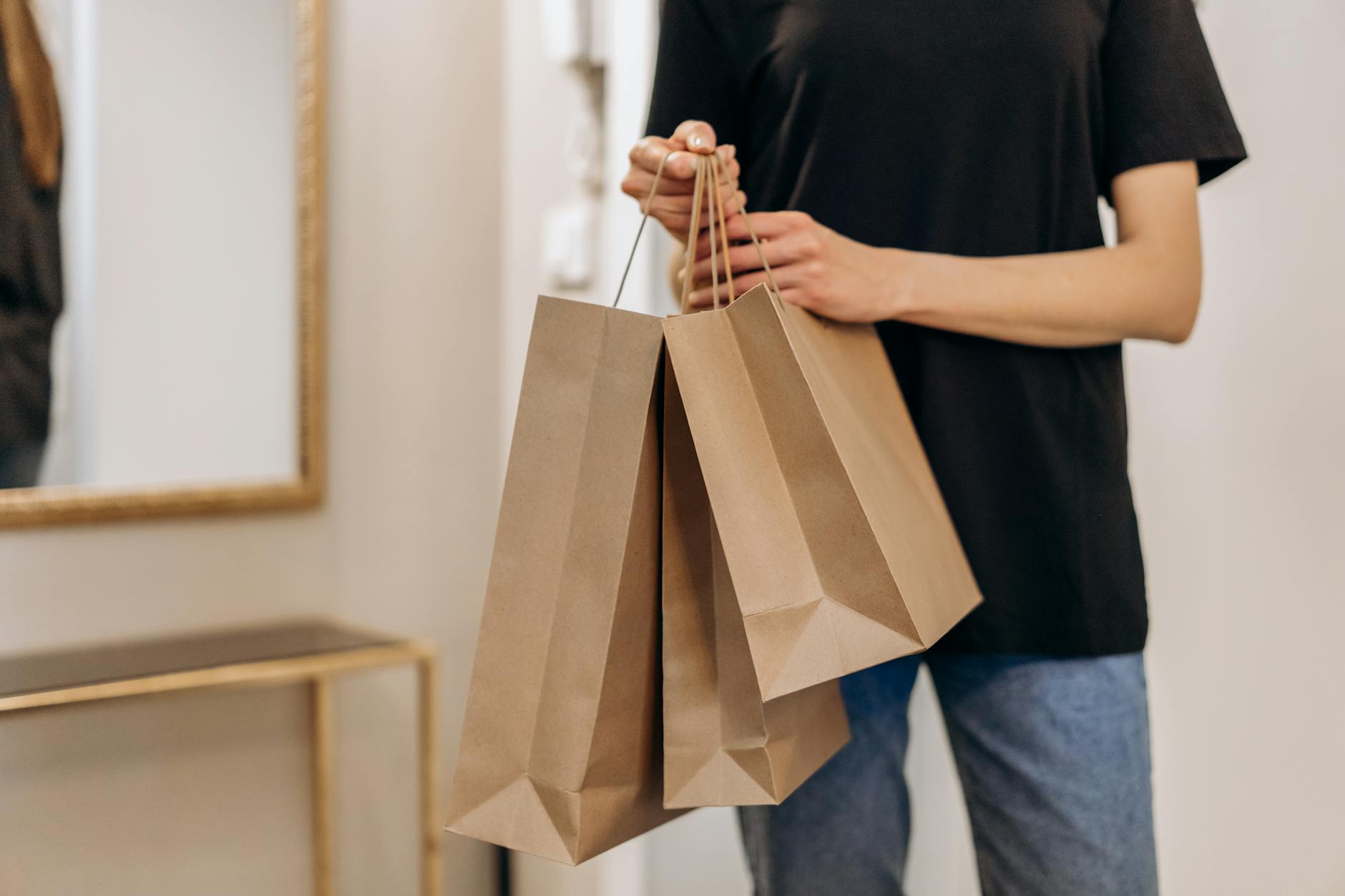 Person holding multiple shopping bags after a successful thrift store shopping trip