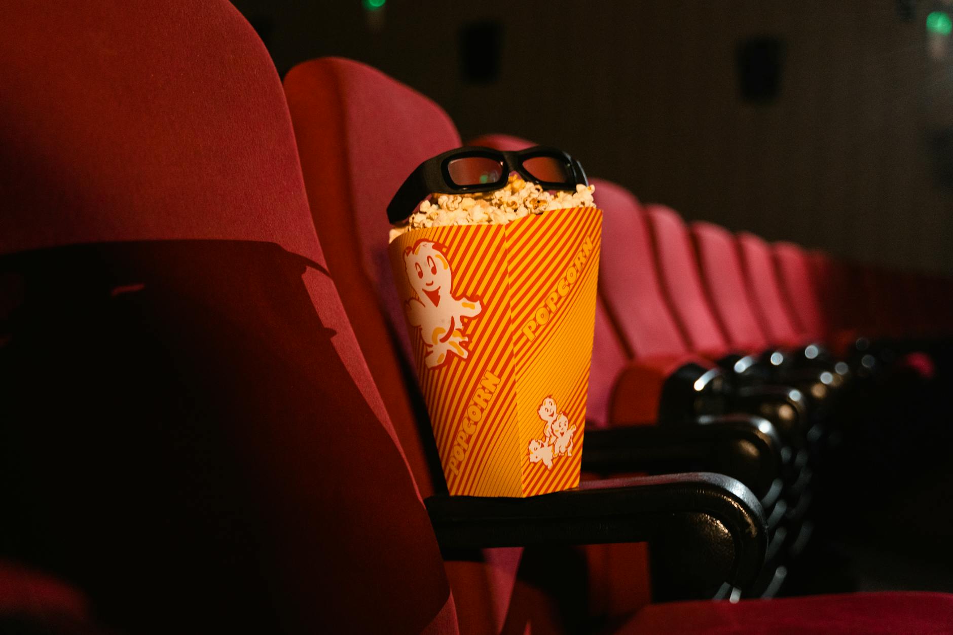 Large movie theater screen illuminated in dark cinema venue