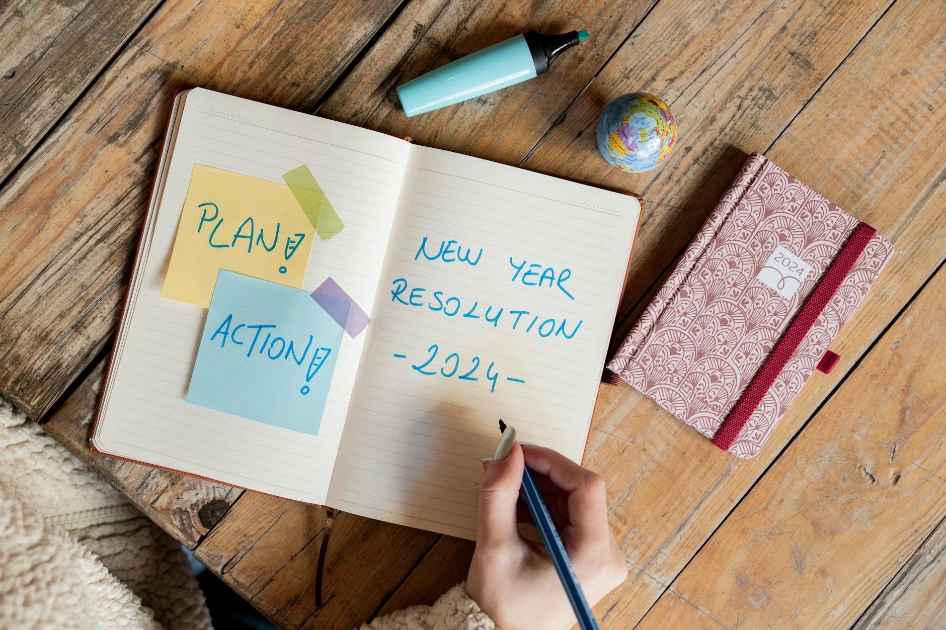 Open notebook with handwritten goals and planning notes on desk