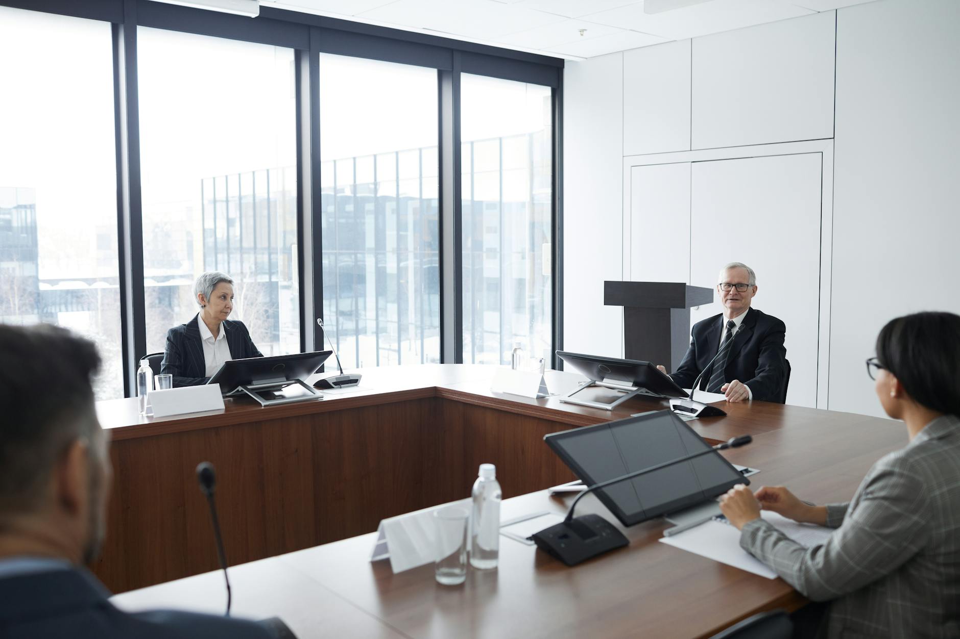 Professional business meeting with executives discussing projects around conference table