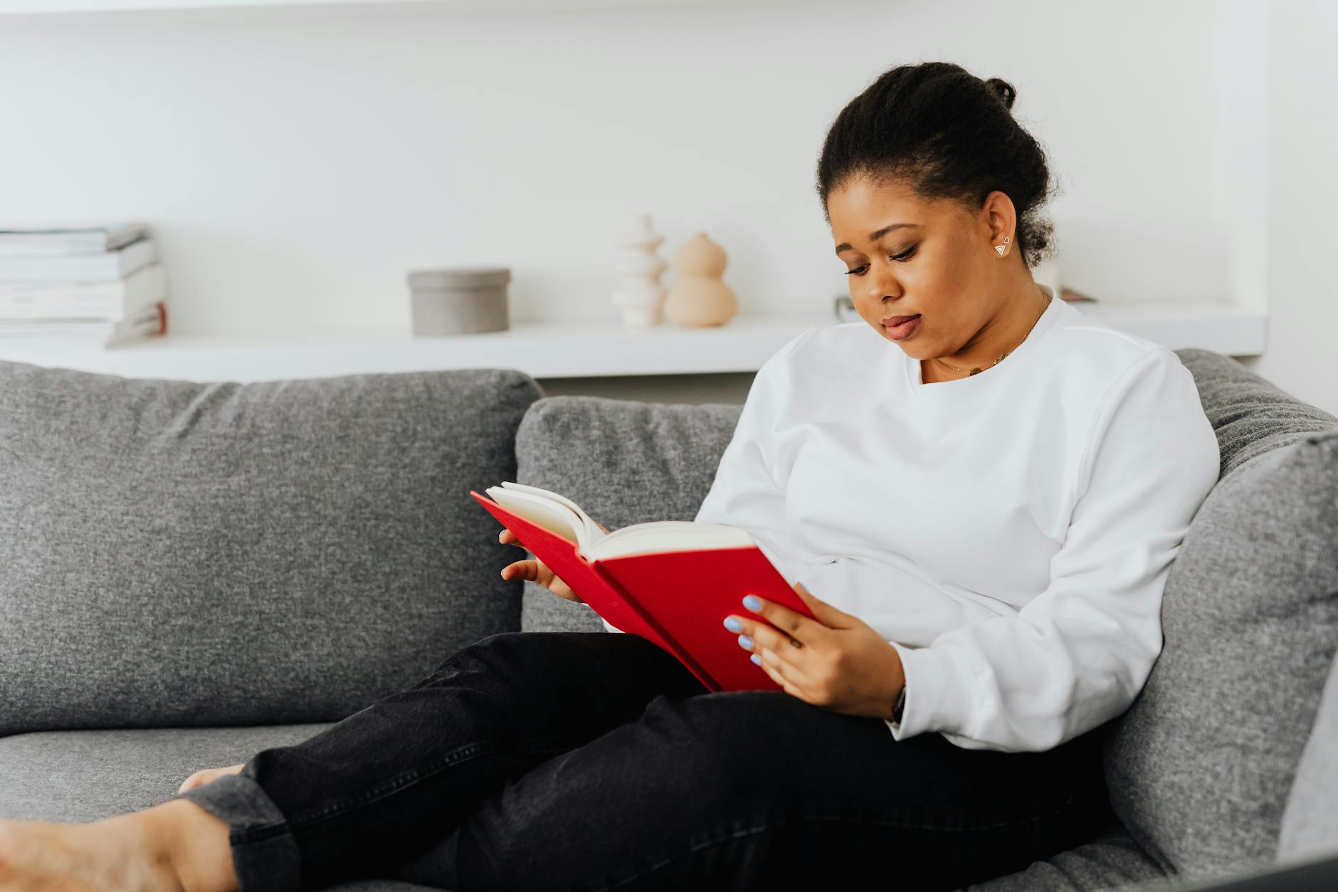 Woman reading book in comfortable setting representing book club culture