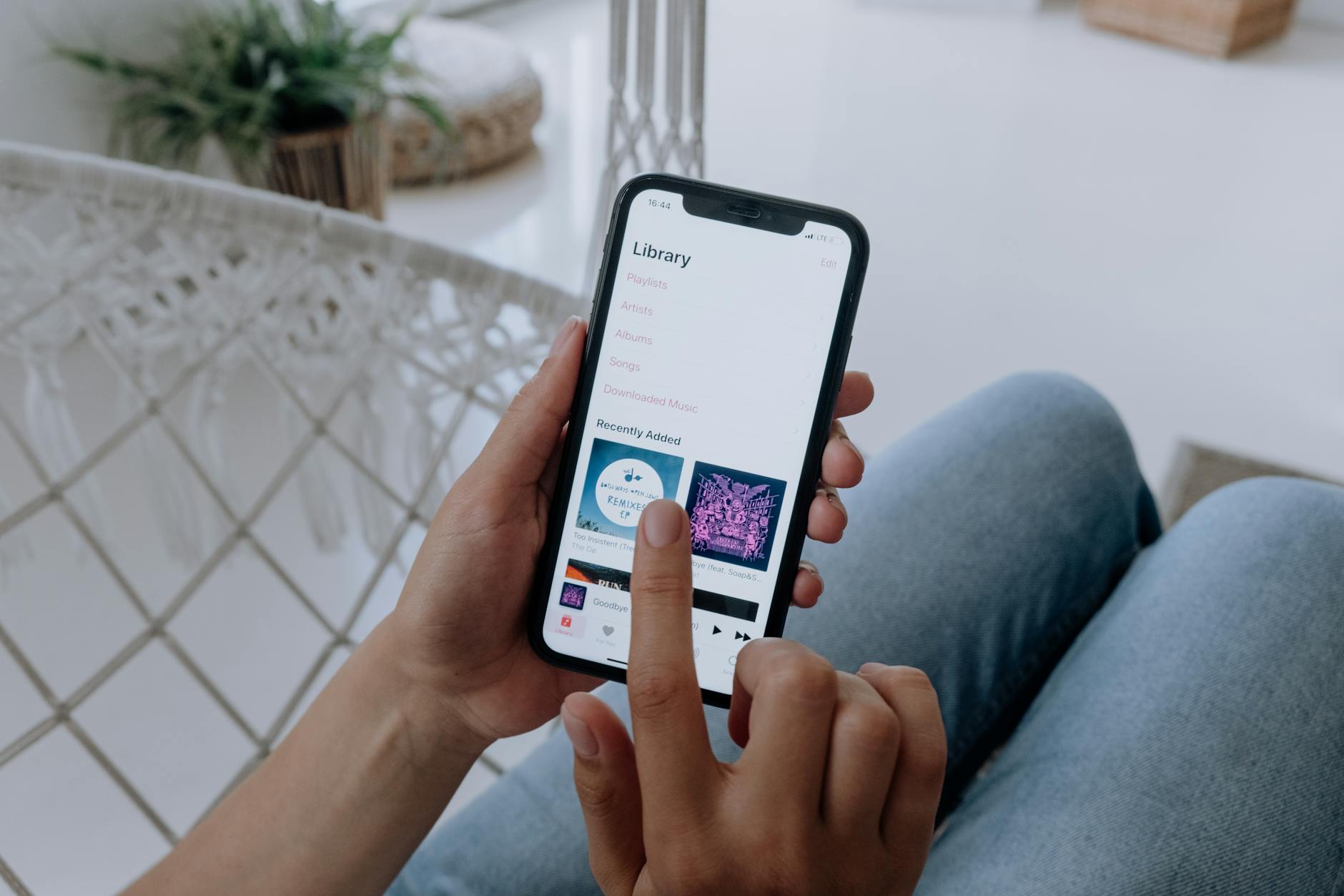 Person holding smartphone displaying streaming video content on screen