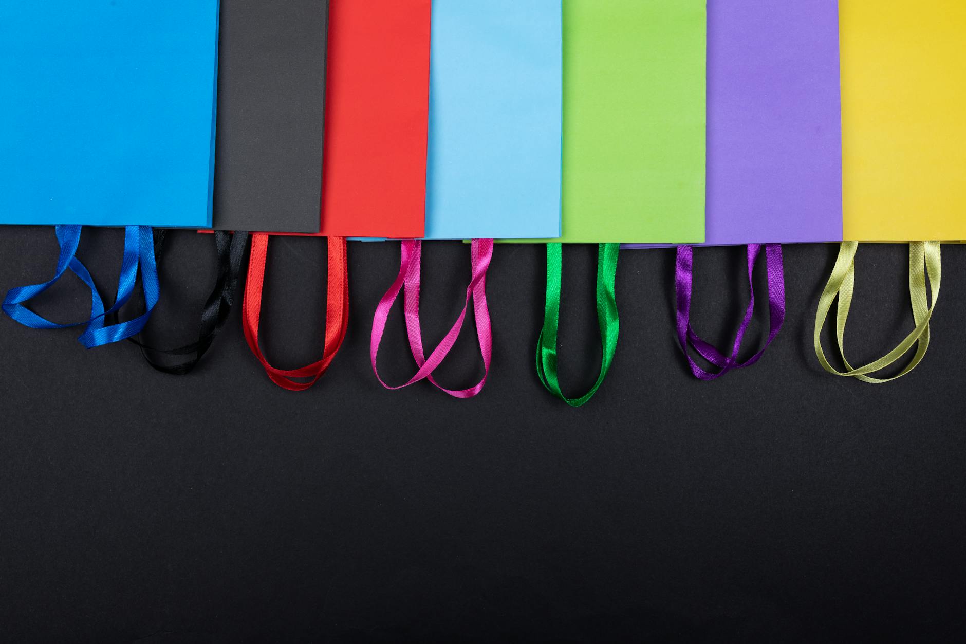 Collection of designer shopping bags representing luxury retail collaboration