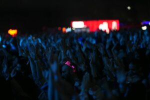 Spotify’s Concert Ticket Push Is Threatening Live Nation’s Dominance Large crowd at an indoor concert venue with stage lighting