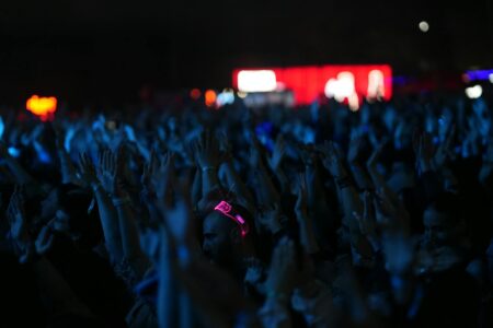Chappell Roan’s Grassroots Fanbase Is Pressuring Major Label Deals Large crowd at a nighttime music concert with stage lights overhead