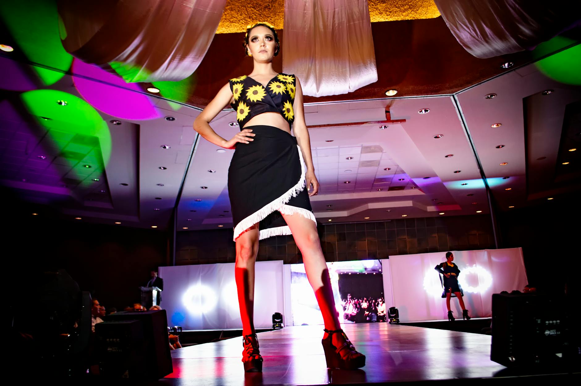 Model wearing bold colorful maximalist outfit on a fashion runway