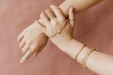 Cartier’s Love Bracelet Is Losing Ground to Signet Rings Stacked gold bracelets and rings displayed on a neutral surface
