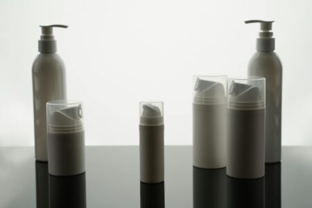 Clean white skincare product bottles arranged on minimalist background