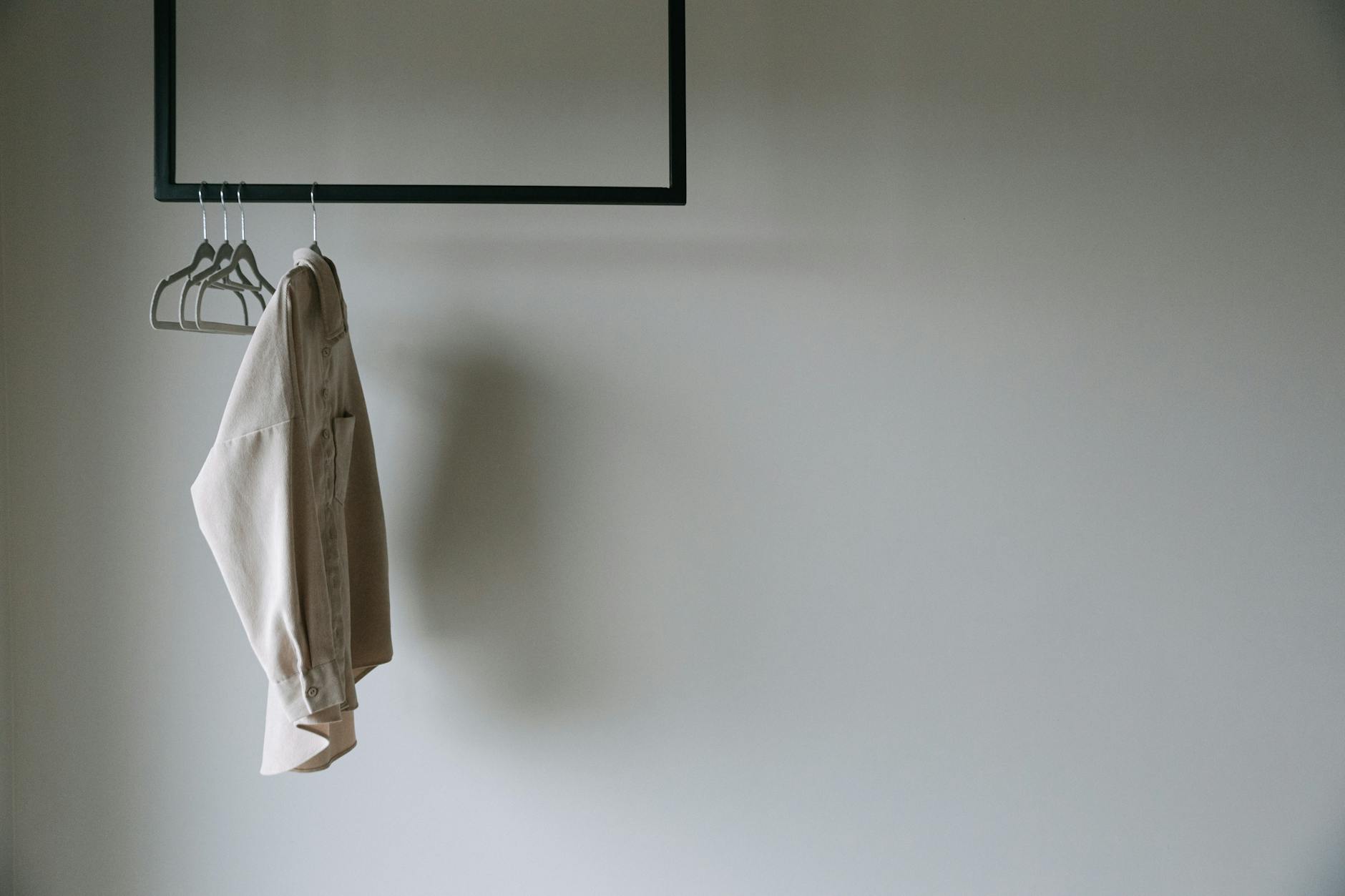 Clean minimalist clothing on a rack with neutral tones and precise tailoring