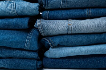 Close-up of premium distressed denim jeans with detailed stitching and hardware