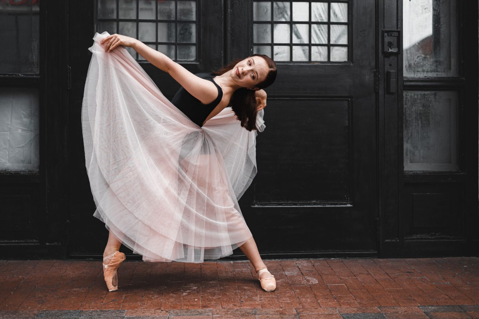 Model wearing layered tulle skirt with structured outerwear in editorial fashion setting