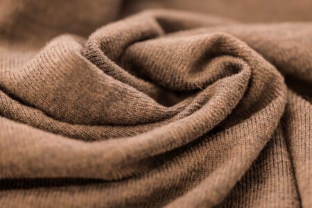 Folded cashmere sweaters in neutral tones arranged on a clean surface