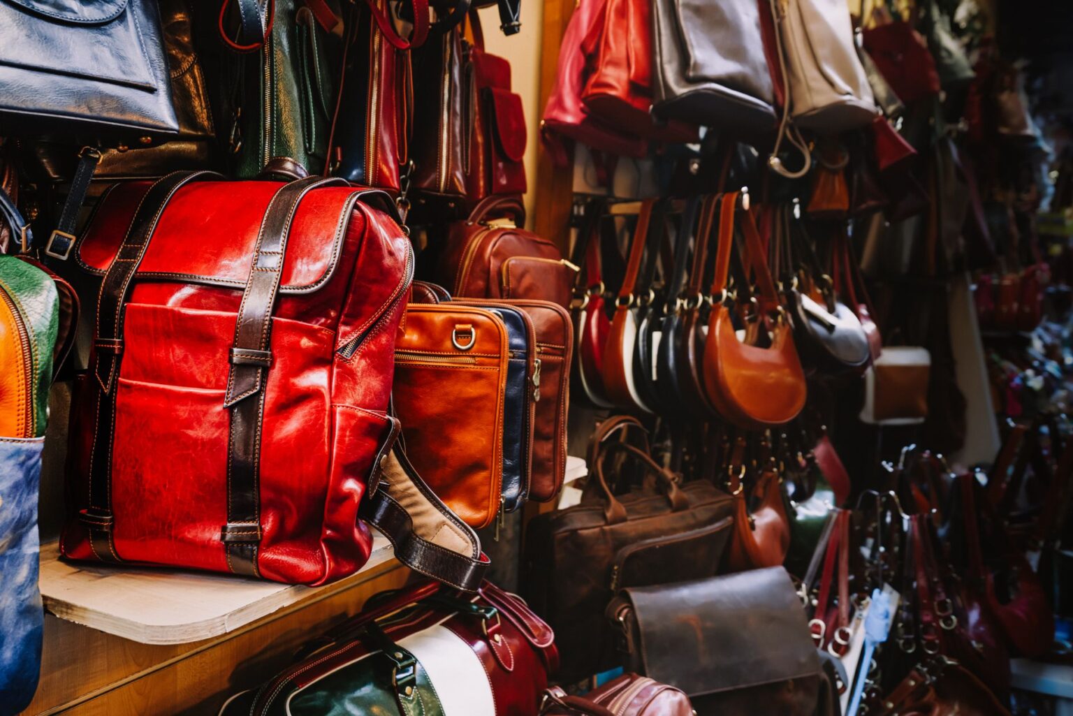 Structured designer handbags displayed on a minimalist shelf in a luxury boutique