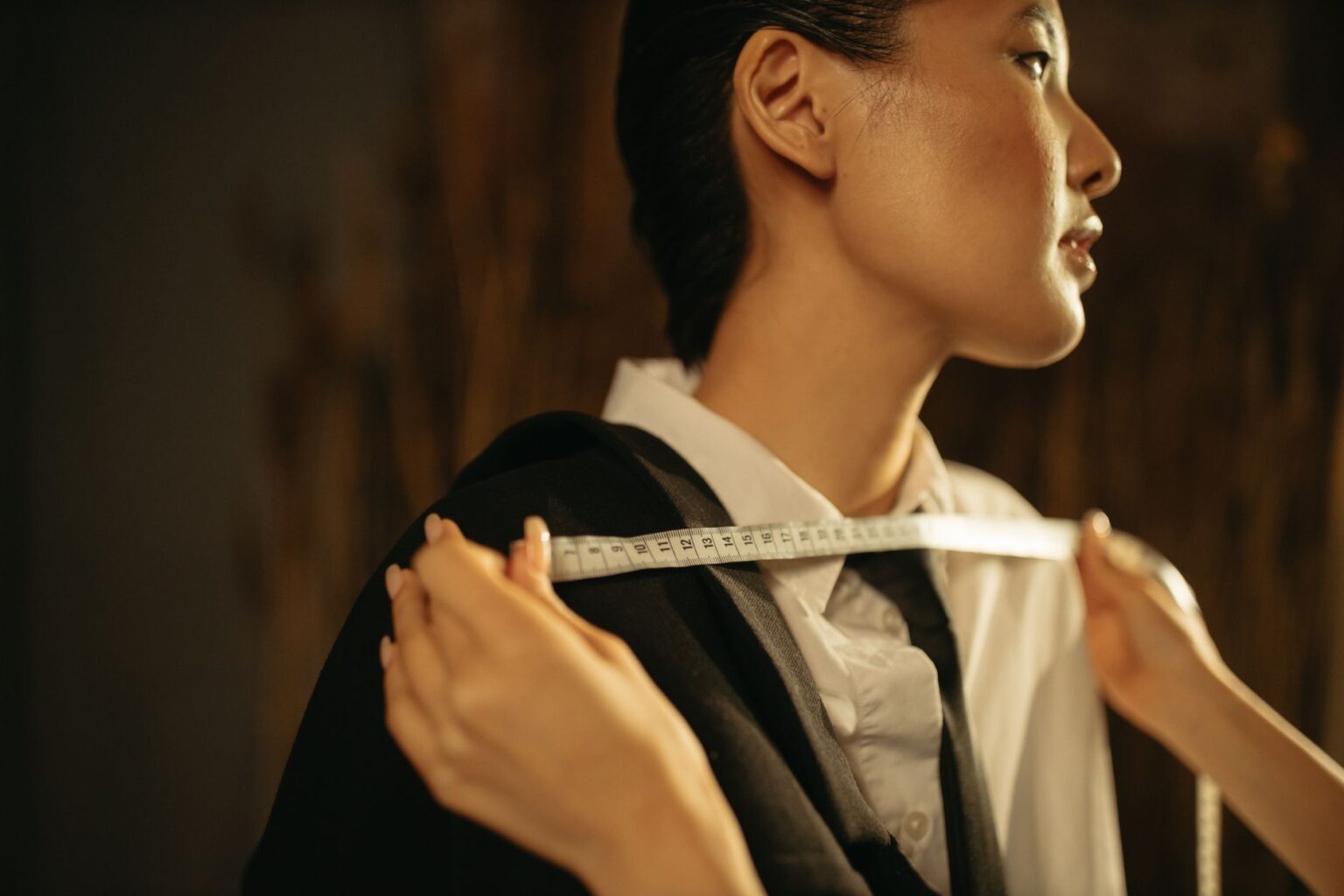 Woman in a sharp tailored blazer and trousers, styled with minimal accessories