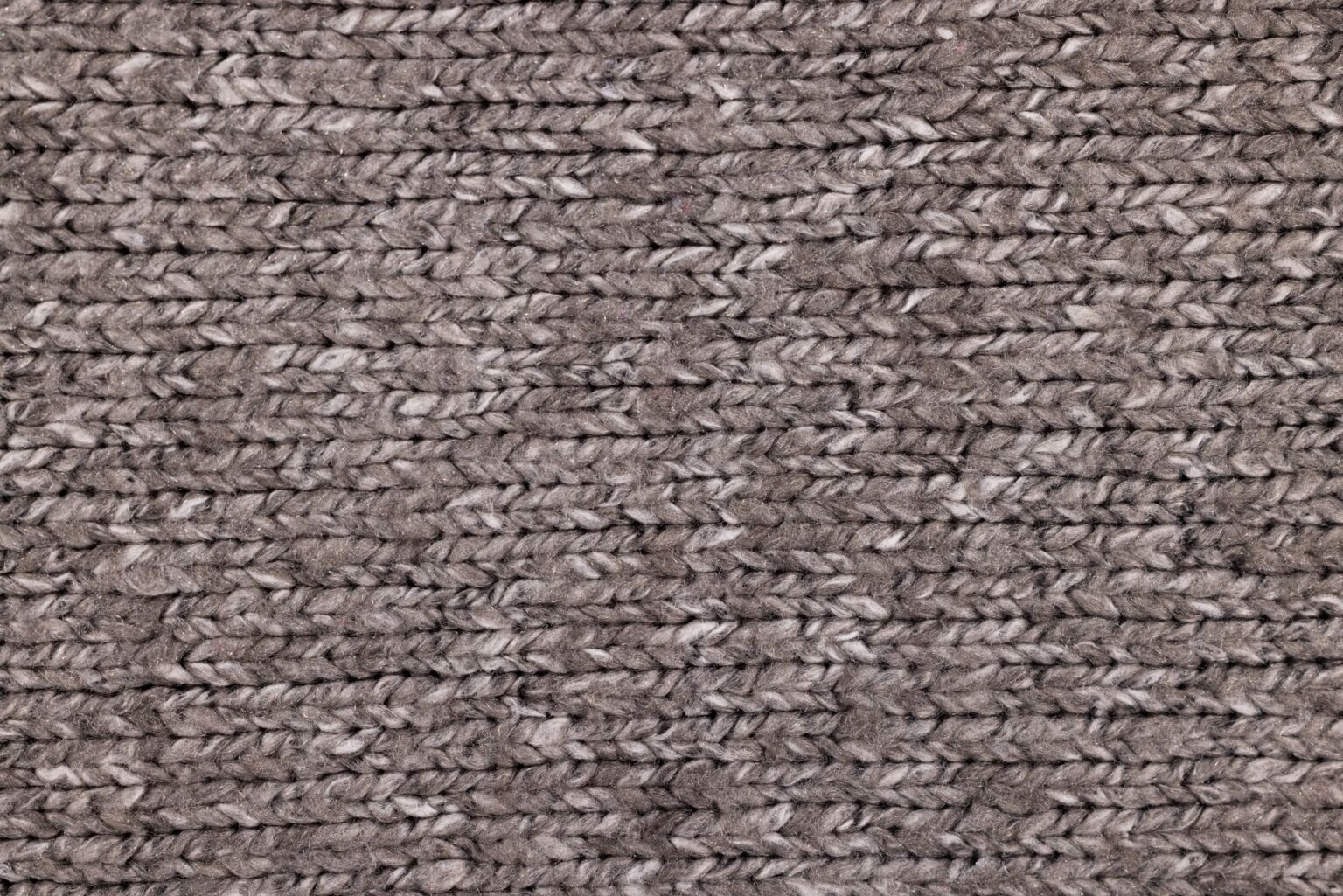 Close-up of textured knitted boots with structured sole, displayed on a clean surface