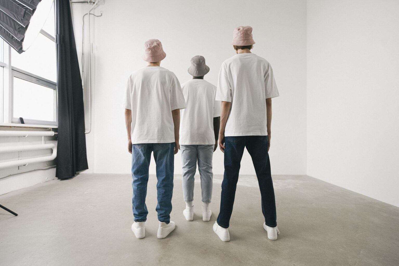 Neatly folded neutral-toned basics including a white shirt and stone trousers on a clean surface