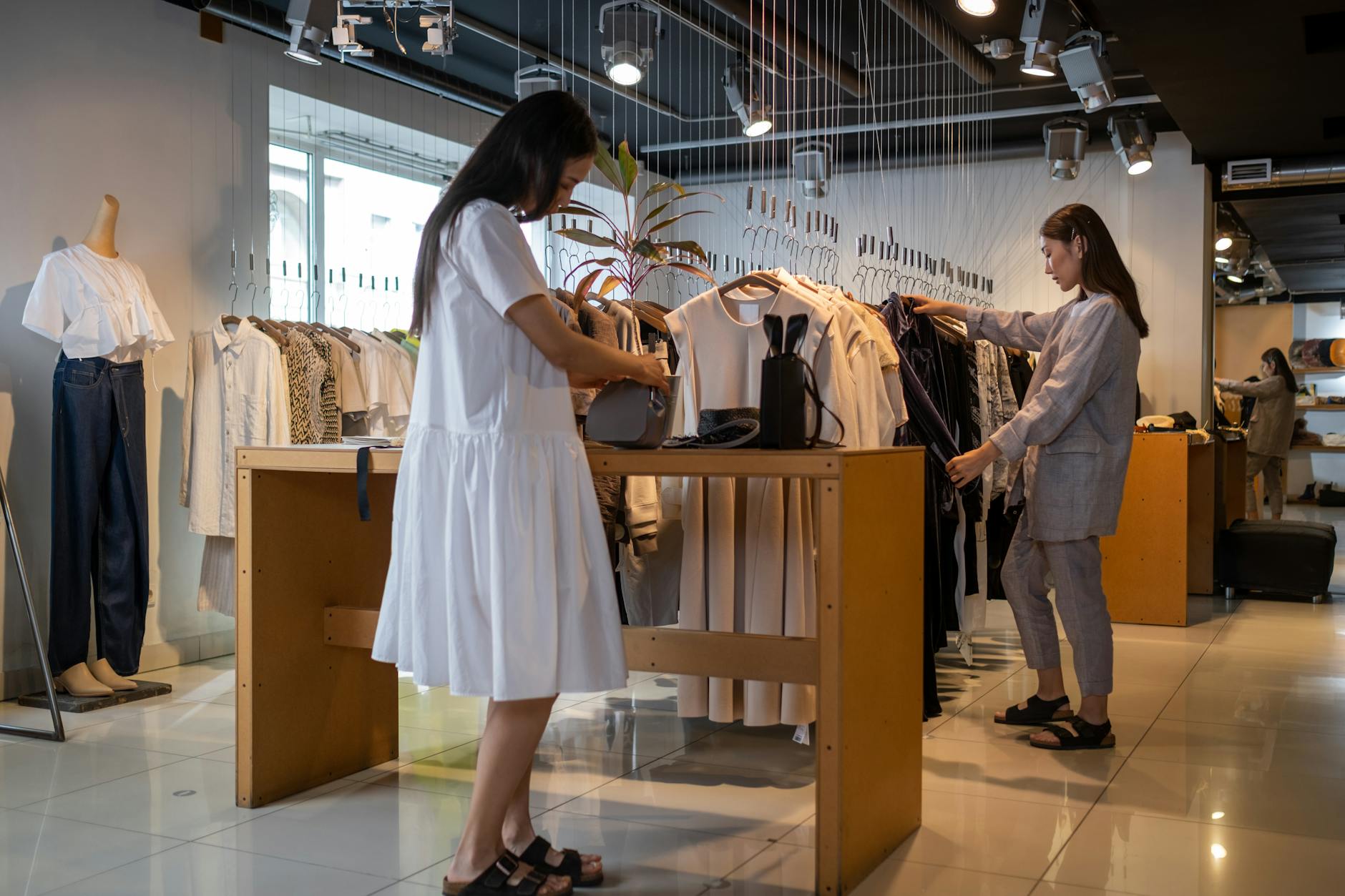 Minimalist luxury fashion boutique with leather goods displayed on clean shelving